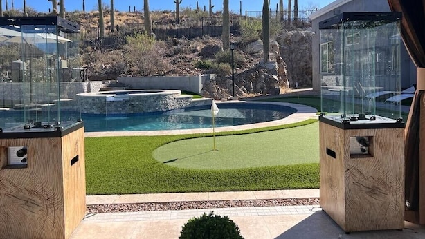 A pool area with a glass enclosure, a small fountain, and a cactus garden in the background. - Elegant West Side Mountain Retreat (Tucson)