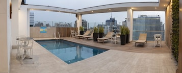 Una piscina al aire libre, tumbonas