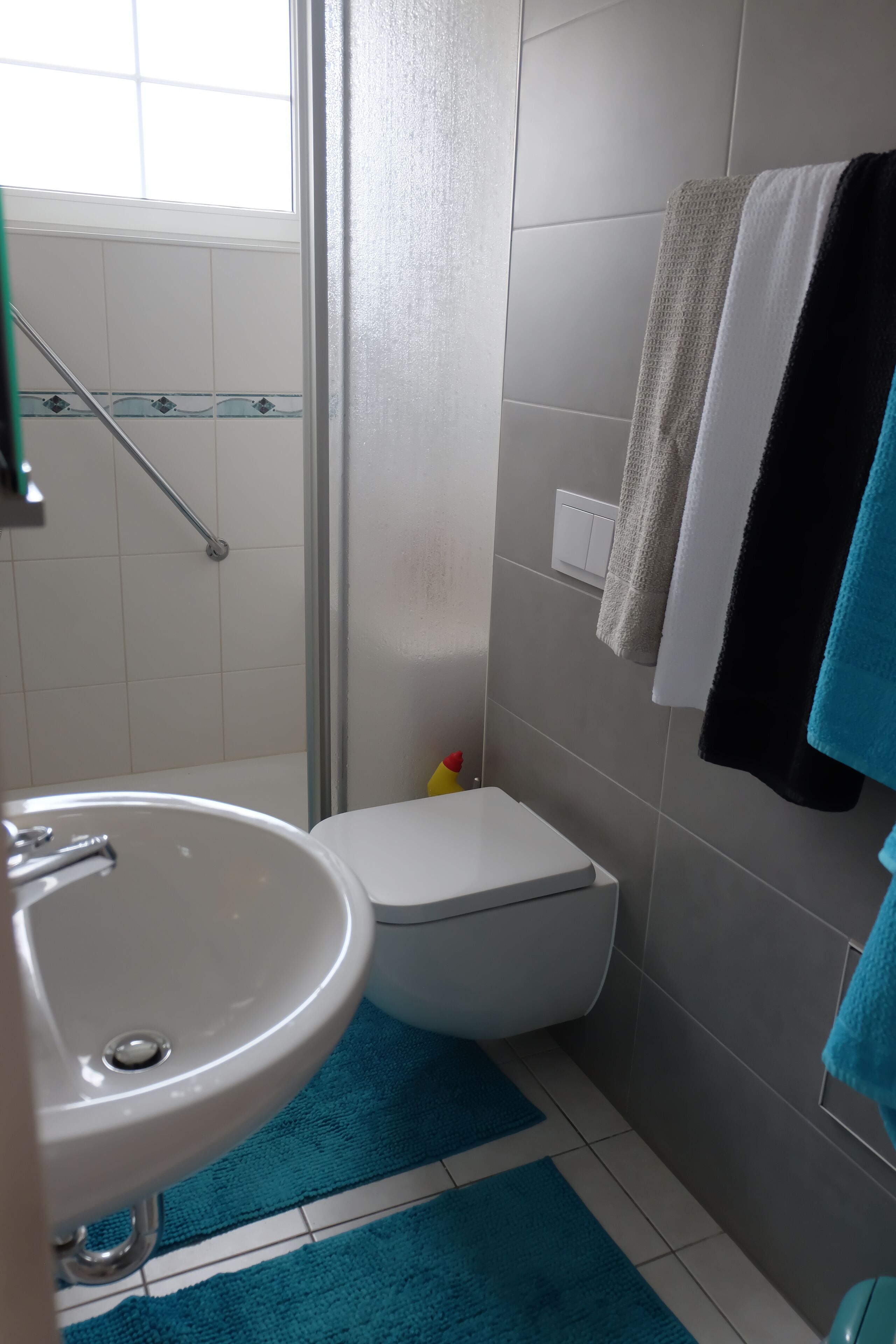 A bathroom with a sink, toilet, and shower area.
