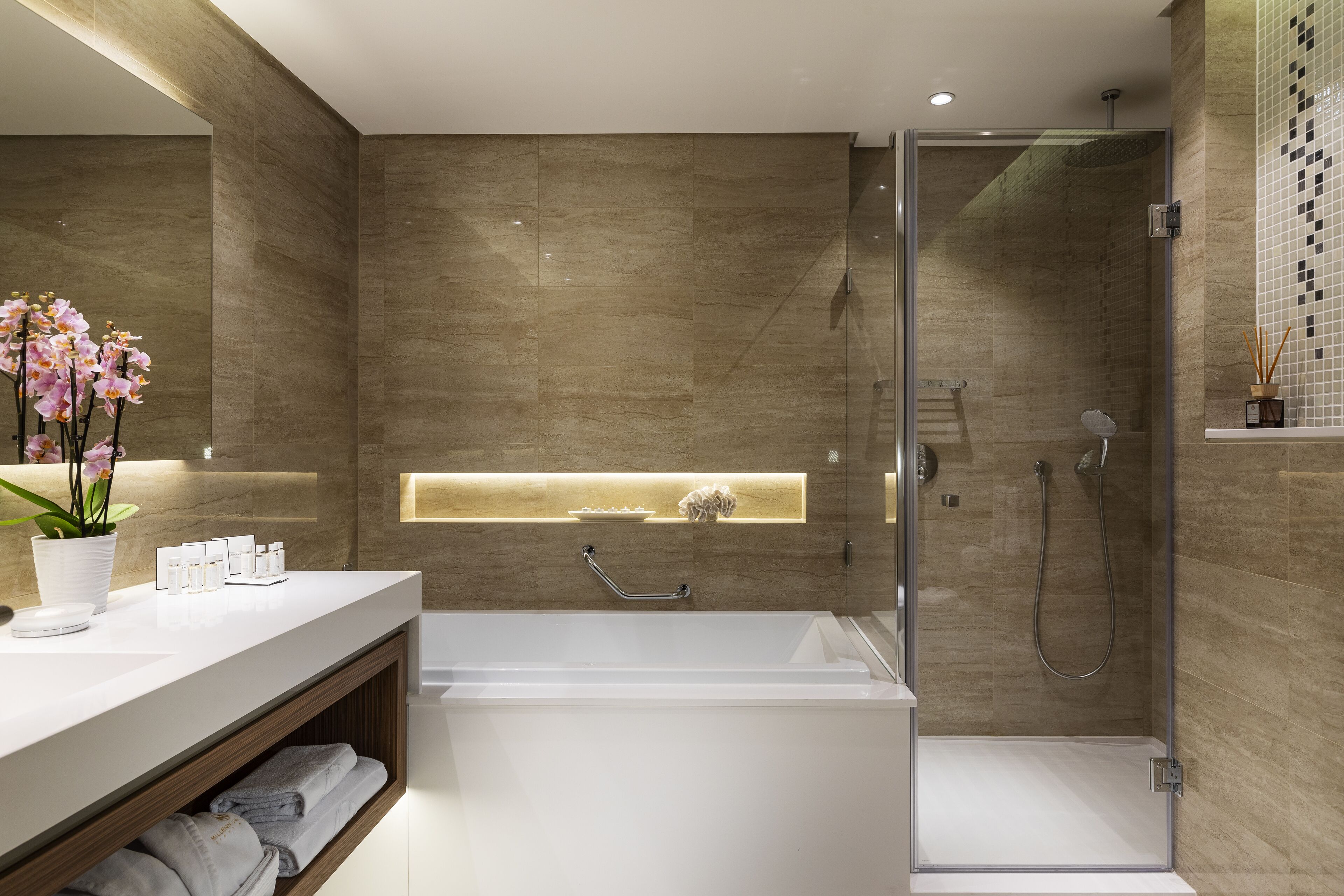 A modern bathroom with a bathtub, shower, and a vanity with a sink and shelves.