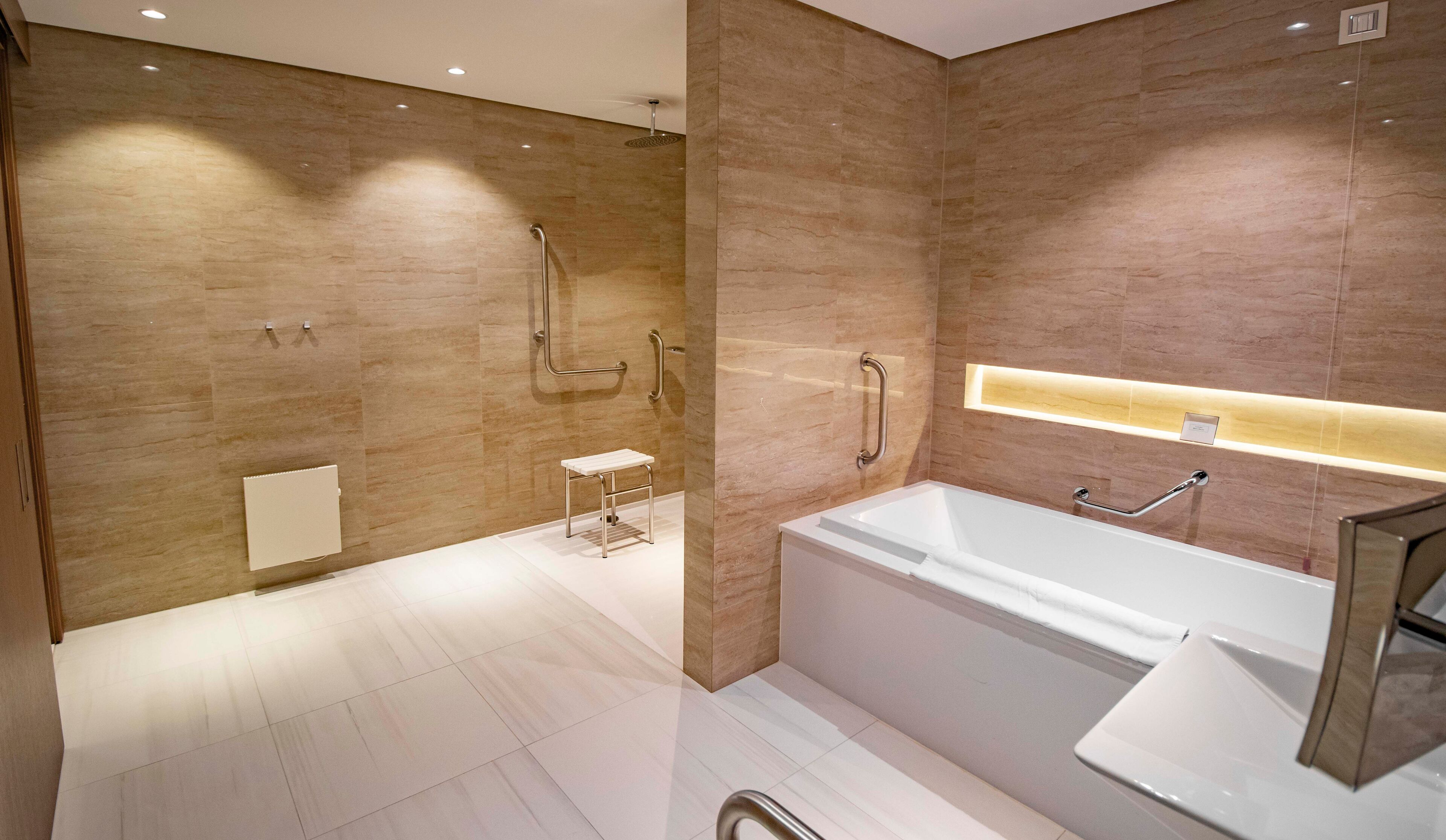 A modern bathroom with a walk-in shower, a standalone bathtub, and a small vanity with a mirror.