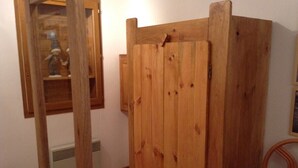 A wooden wardrobe with a mirror and a radiator in a room.