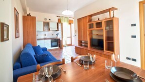 A modern kitchen with wooden cabinets and a dining area with a table set for two.