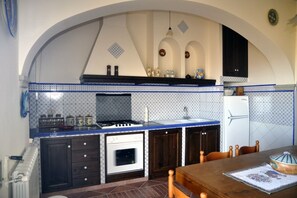 Una cocina con encimera azul, estufa blanca y armarios de madera oscura.