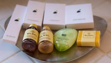Una bandeja con varios productos para el cabello ELSYL, incluyendo champú, acondicionador y una barra de jabón.