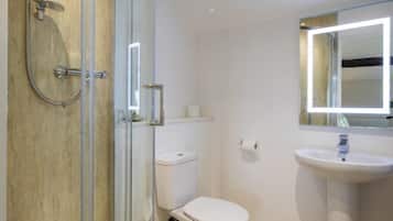 A bathroom with a glass-enclosed shower, a white toilet, and a pedestal sink.