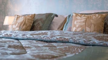 A bed with a patterned bedspread and multiple pillows.