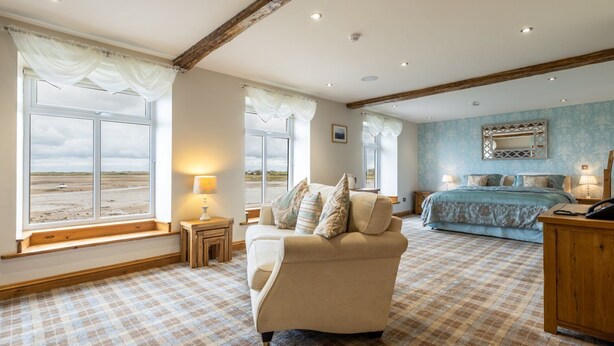 A bedroom with a large window, a bed, a sofa, and a desk. - The Inn at Ravenglass (Ravenglass)