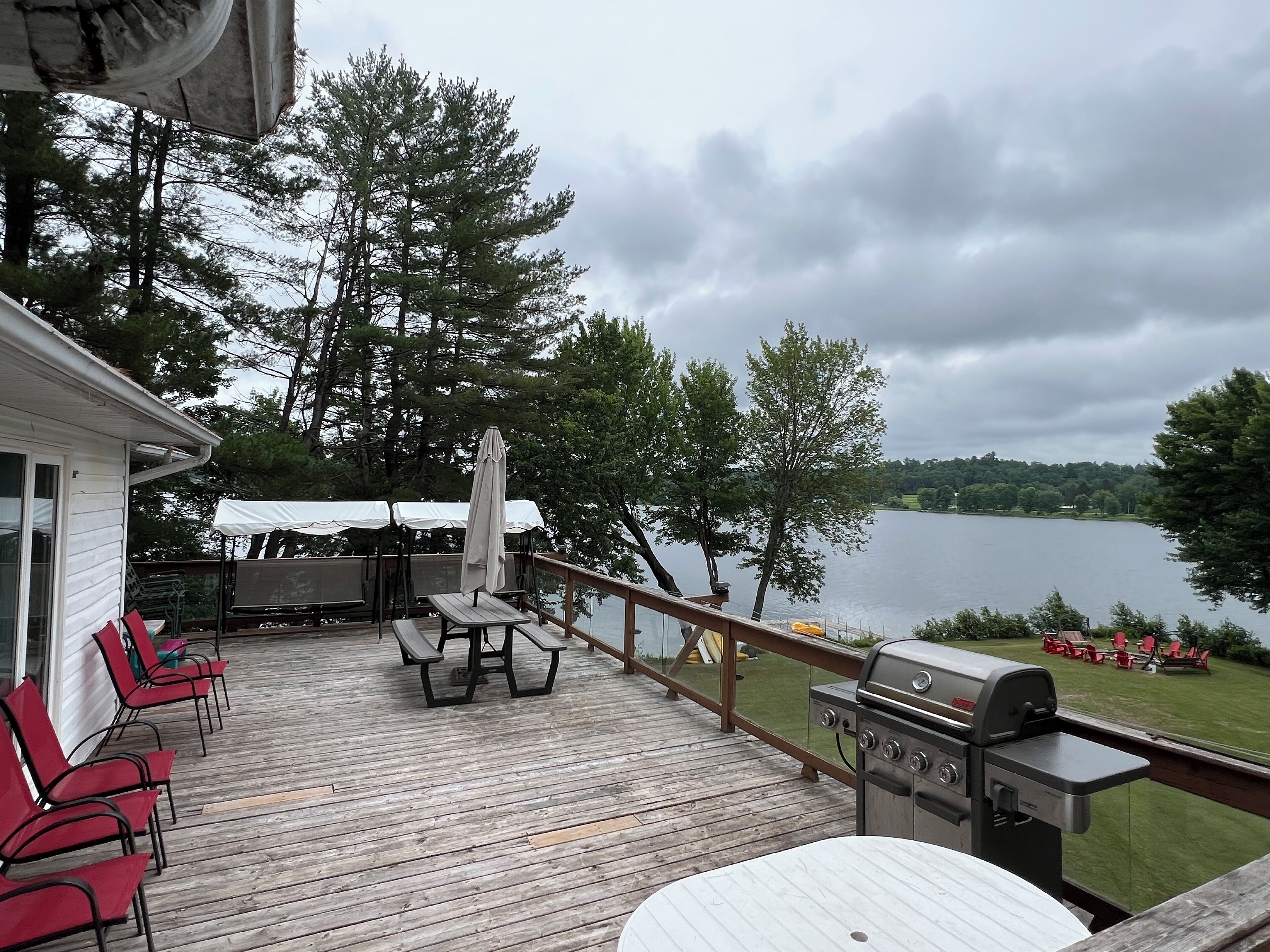 Raised deck facing backyard/lake, large bbq, 2 swings, 2 tables and lots chairs 