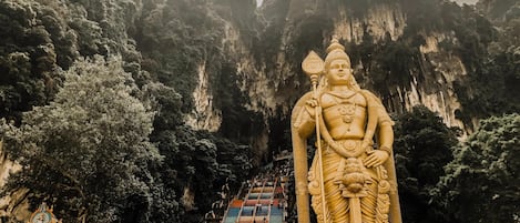 Eine große goldene Statue vor einem Tempel, verbunden mit einer Treppe.
