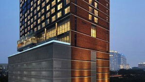 Un hotel de gran altura con varios pisos, amplias ventanas y un cartel llamativo en la parte superior.