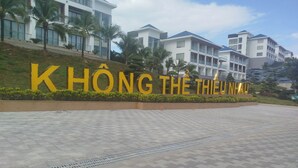 En moderne bygning med store gule bogstaver, der staver "KHÔNG THE THIÊU NHAU" på facaden.