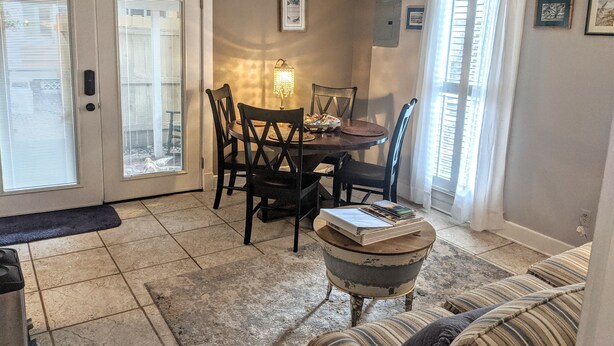 A dining area with a table, chairs, and a chandelier.