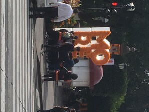 Guests can gather around the public bus, surrounded by lush greenery and a nearby street lamp.