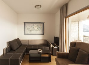 Appartement Deluxe, 2 chambres, vue mer | Coin séjour | Télévision à écran plat de 32 pouces avec chaînes numériques, télévision