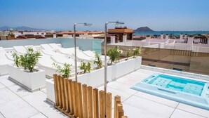 A rooftop pool area with a jacuzzi, white tiled flooring, and a wooden fence. - Hotel Vacanzy Urban Boutique - Adults Only (La Oliva)