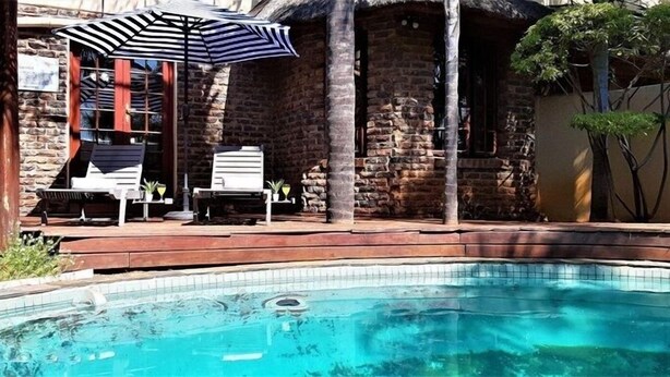 Una piscina al aire libre, sillones reclinables de piscina