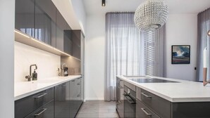 A modern kitchen with dark cabinetry, a white countertop, and a large island.