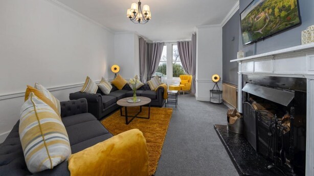 Ein modernes Wohnzimmer mit Sofa, Couchtisch und Kamin.