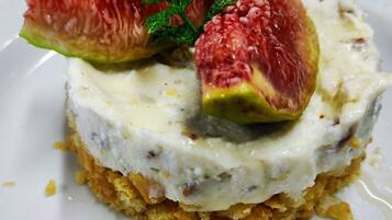 A dessert with a creamy base, topped with a fruit slice and a mint leaf.