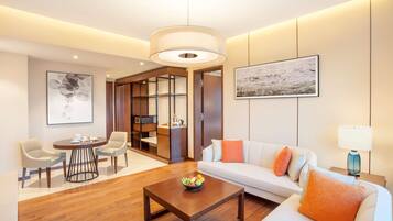 Una sala moderna con una mesa de centro de madera, un sofá blanco y sillas color beige.