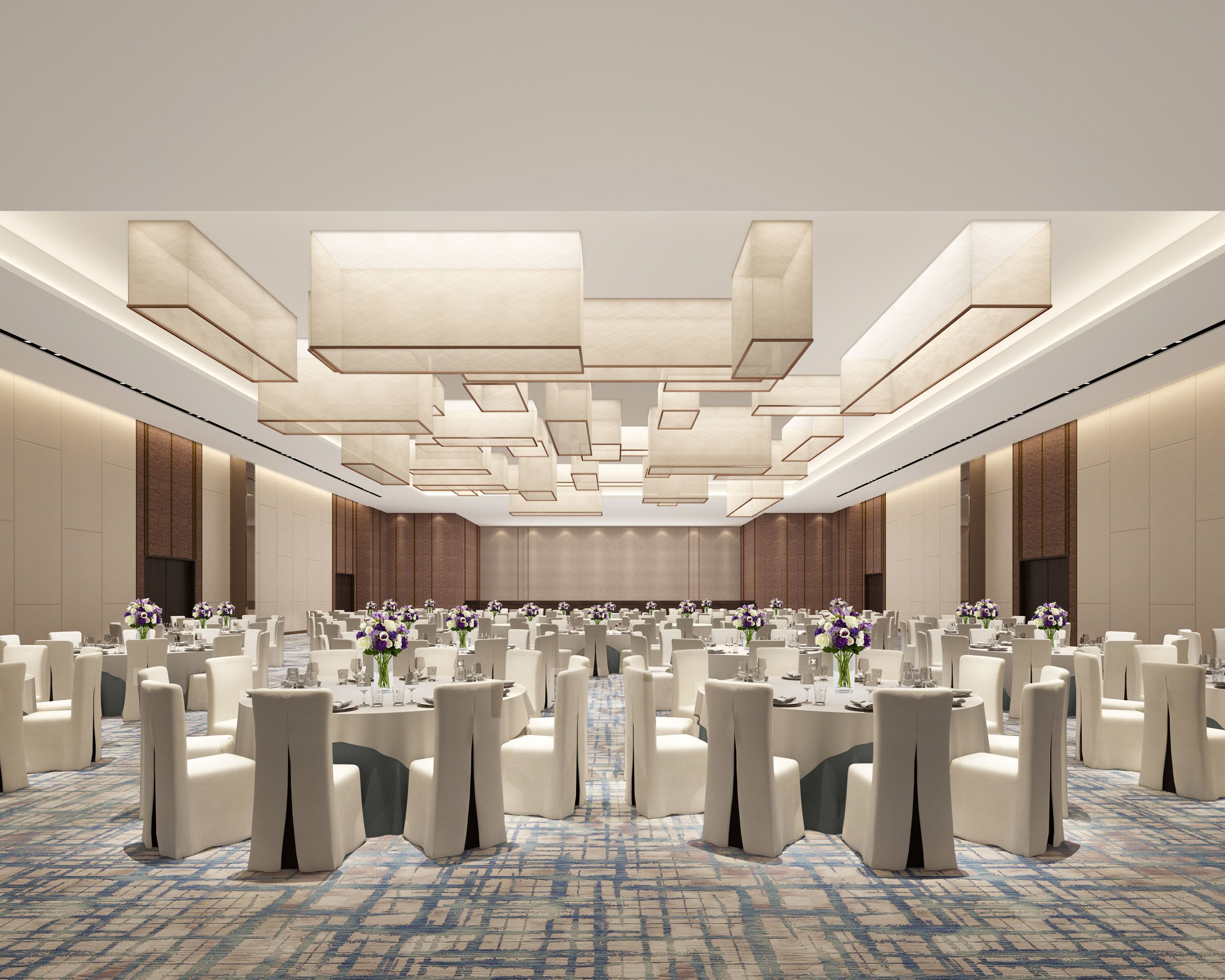 A large conference room with a modern ceiling design, multiple tables with chairs, and a patterned carpet.
