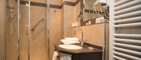 A modern bathroom with a glass-enclosed shower, a sink with a vanity, and a hairdryer on a white towel rack.