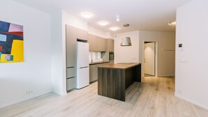 A modern kitchen with a central island, built-in appliances, and recessed lighting. - Tower Apartments (Reykjavik)