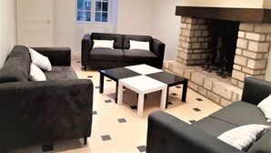 A living room with a fireplace, two sofas, and a coffee table.