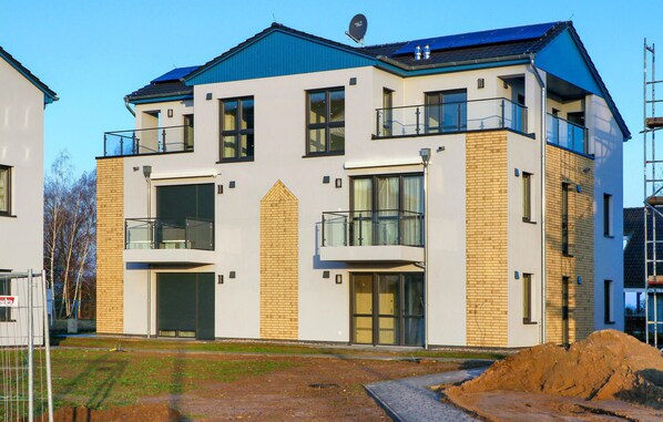 A modern multi-story building with a flat roof, large windows, and balconies. - 1 bedroom nice apartment in Rechlin (Rechlin)