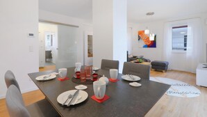 A modern dining area with a dark wooden table set for four, surrounded by grey upholstered chairs. - 1 bedroom nice apartment in Rechlin (Rechlin)