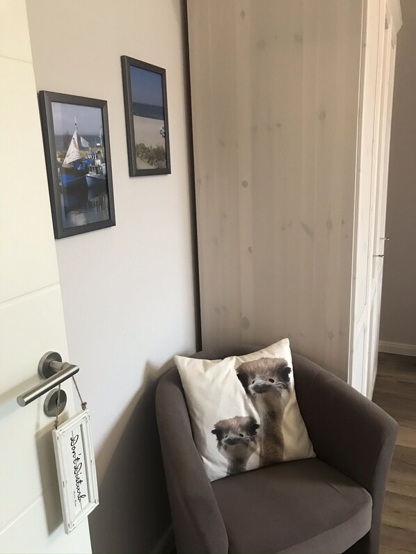 A room with a grey sofa, a white door, and two framed pictures on the wall. - Luxurious apartment for 4 persons with parking directly in front of the terrace (Kühlungsborn-West)