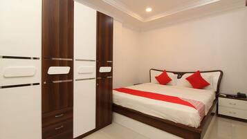 A bedroom with a bed, a wardrobe, and a nightstand.