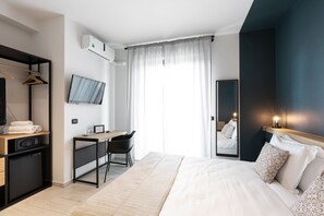 A modern hotel room with a bed, desk, chair, and a TV mounted on the wall. - Attico43 Bed & Breakfast (Florence)