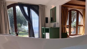 A room with a large window, a desk, and a chair.