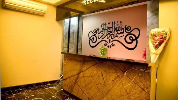 Un comptoir d’accueil avec un plateau en marbre et une enseigne indiquant « RECEPTION » en anglais et en arabe.
