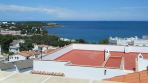 A rooftop terrace with a red roof, overlooking a coastal area with buildings and the sea. - Fake penthouse with sea views and a large terrace (Llançà)