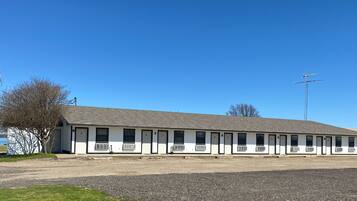 A motel with a row of single-story rooms, each with a door and a window.