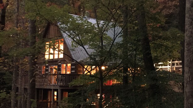 A cabin with a wooden exterior, multiple windows, and a balcony.