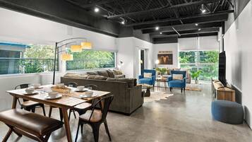 Ein stilvolles Wohnzimmer mit Essbereich, Sofas und Fernseher.