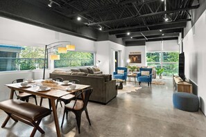 Un espacio moderno para vivir con comedor, sofás y televisor.