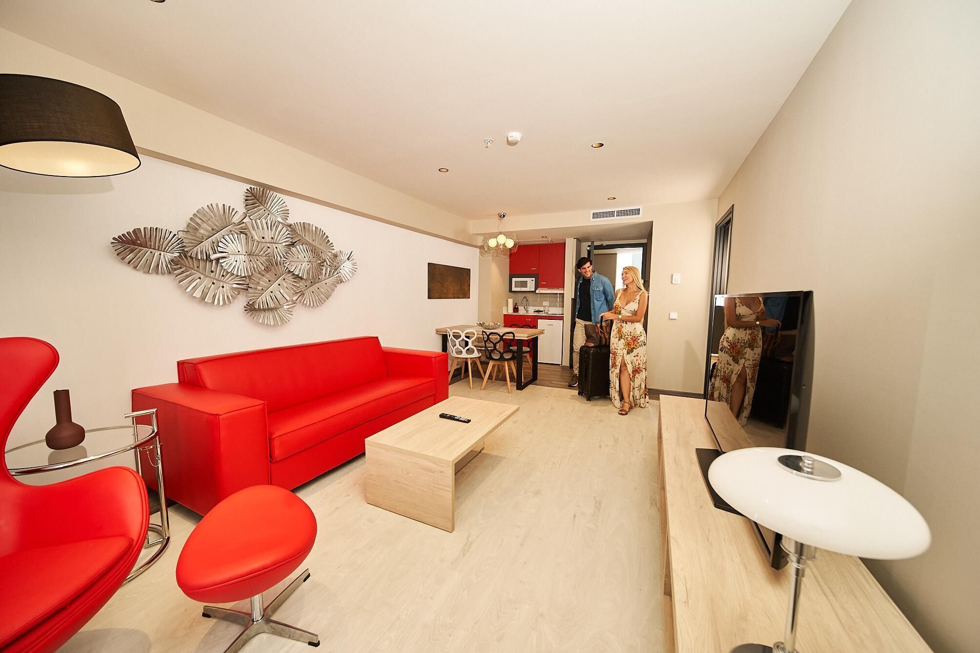 Una sala de estar moderna con un sofá rojo, una mesa de centro y un televisor.