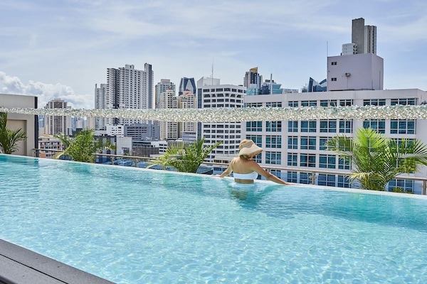 Una piscina al aire libre, sillones reclinables de piscina