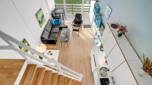 Ein modernes Interieur mit Treppe, Essbereich, einer Couch und einer Küche.