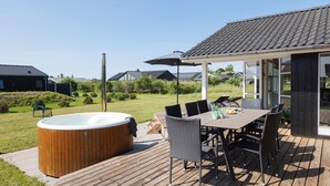 A patio with a hot tub, outdoor furniture, and a covered seating area. - 3 bedroom lovely home in Jægerspris (Jægerspris)
