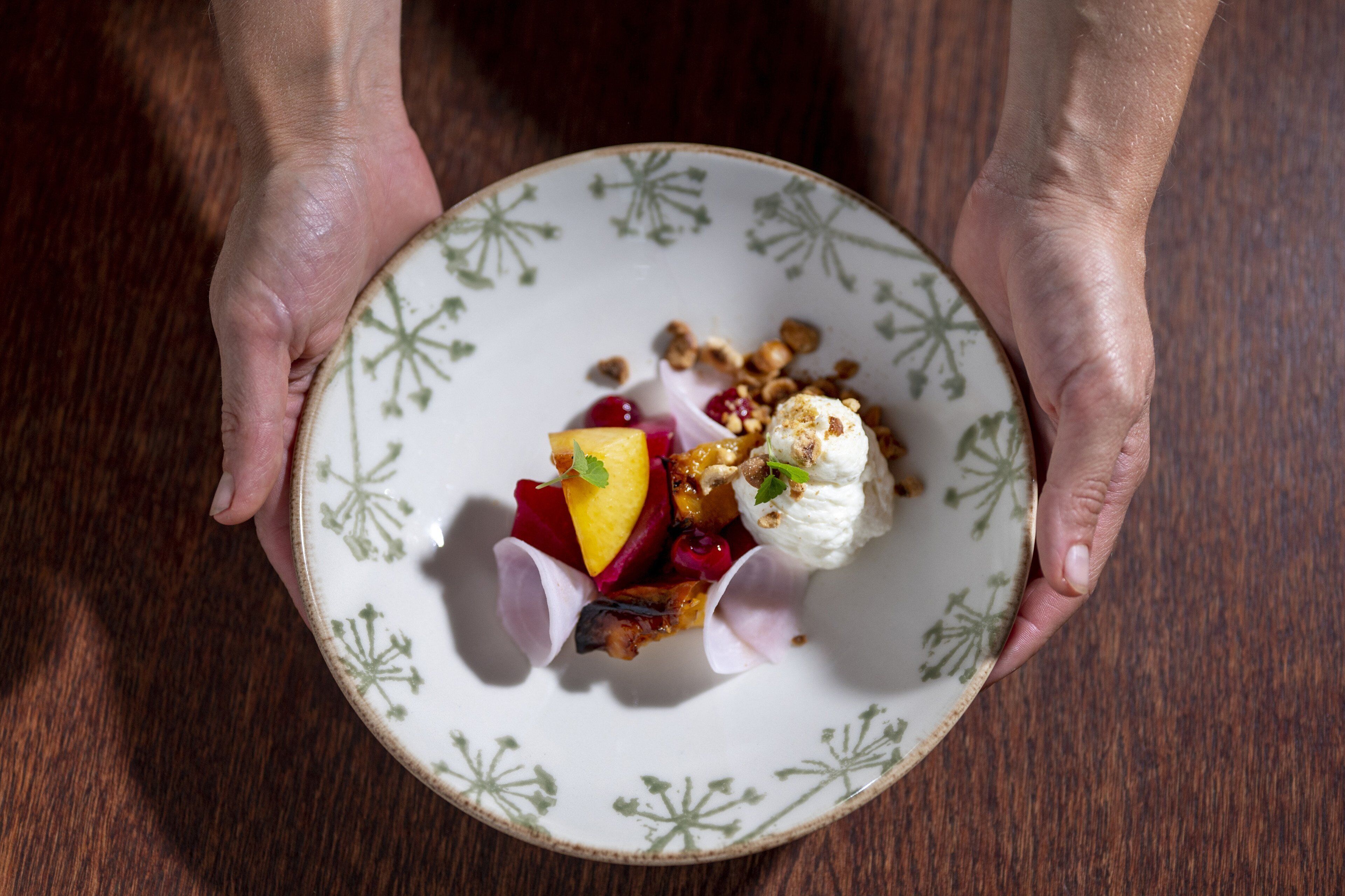 A person holding a plate with a dessert.
