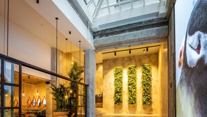 Een modern interieur met een hoge plafond, zichtbare balken en een centrale trap.