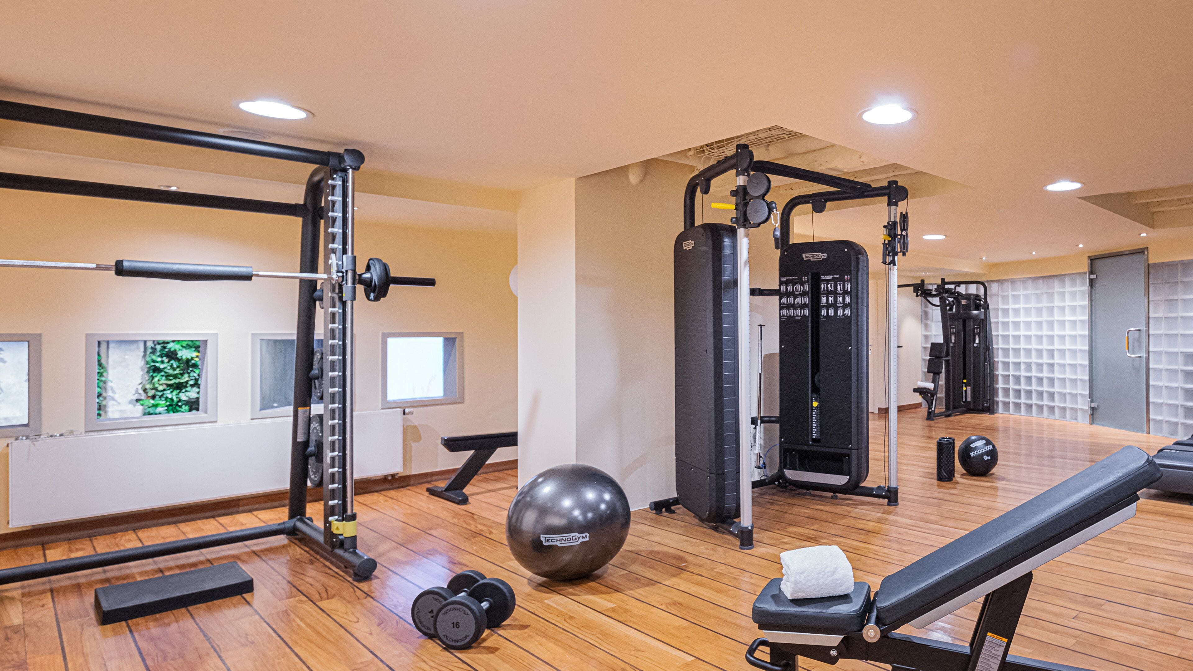 Een sportschool met trainingsapparatuur, een bank en een bal.