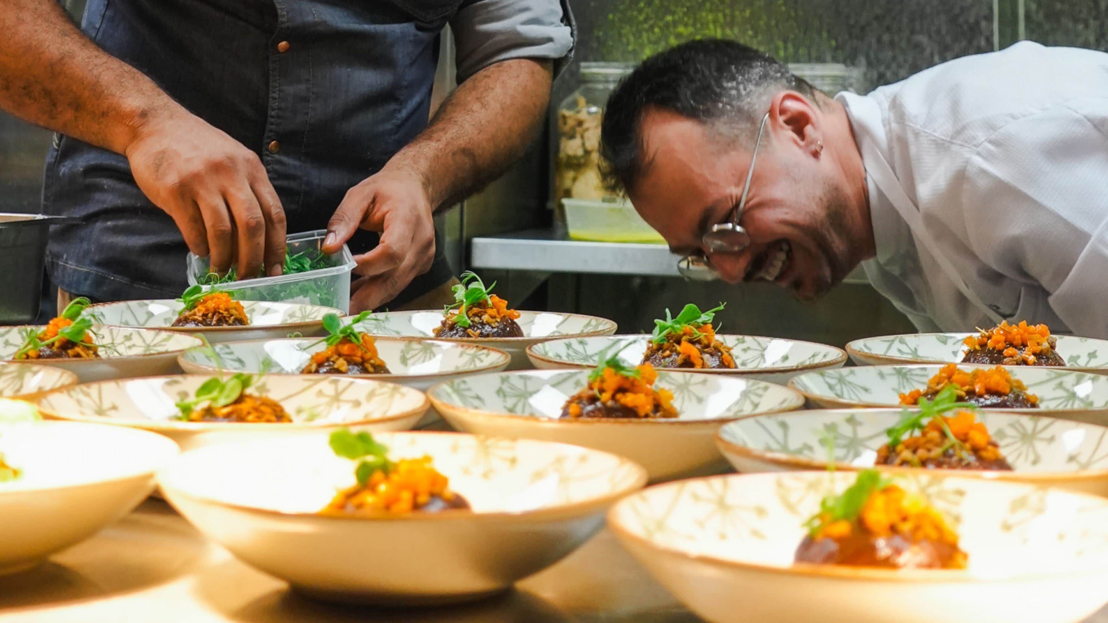 A chef preparing dishes in a professional kitchen.