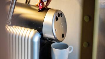 Une cuisine moderne équipée d’une machine à café intégrée et d’une tasse blanche.